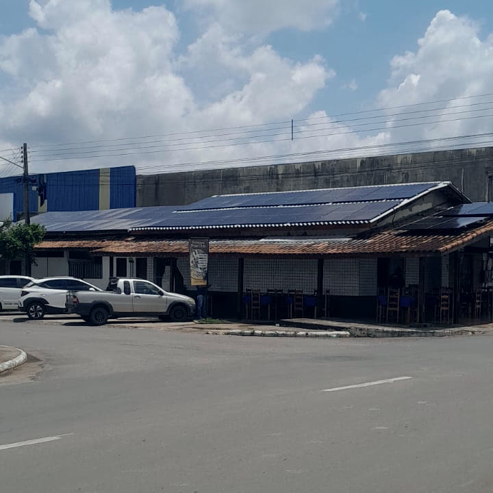 Fachada de um comércio em Ji-Paraná com os painéis solares instalados no telhado, vista da rua.